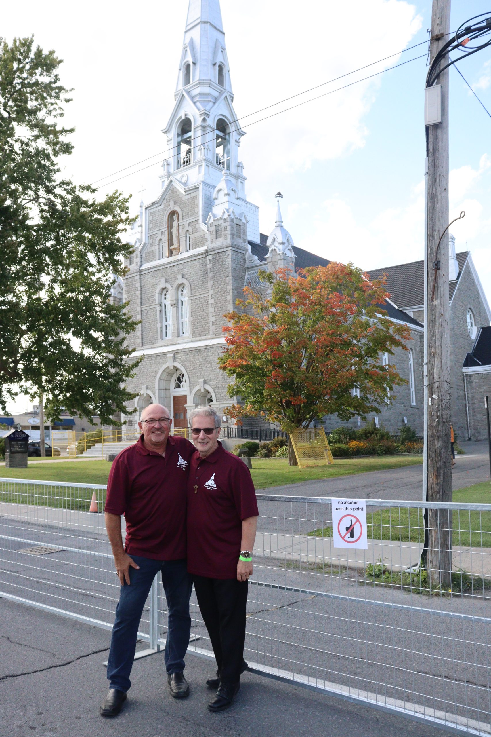 Laurier Lemieux, président de C.A.T. (gauche), et l’abbé Michel Pommainville (droite) debout devant l’église. 