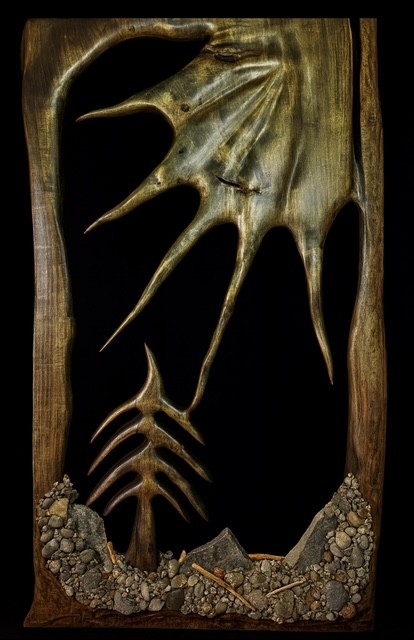 « Souvenir d’enfance », une sculpture façonnée dans une planche massive de peuplier, évoque le lac de l’adolescence de Sylvain Séguin. Les pierres, bois flotté et cocottes intégrés proviennent directement de ce lieu marquant.